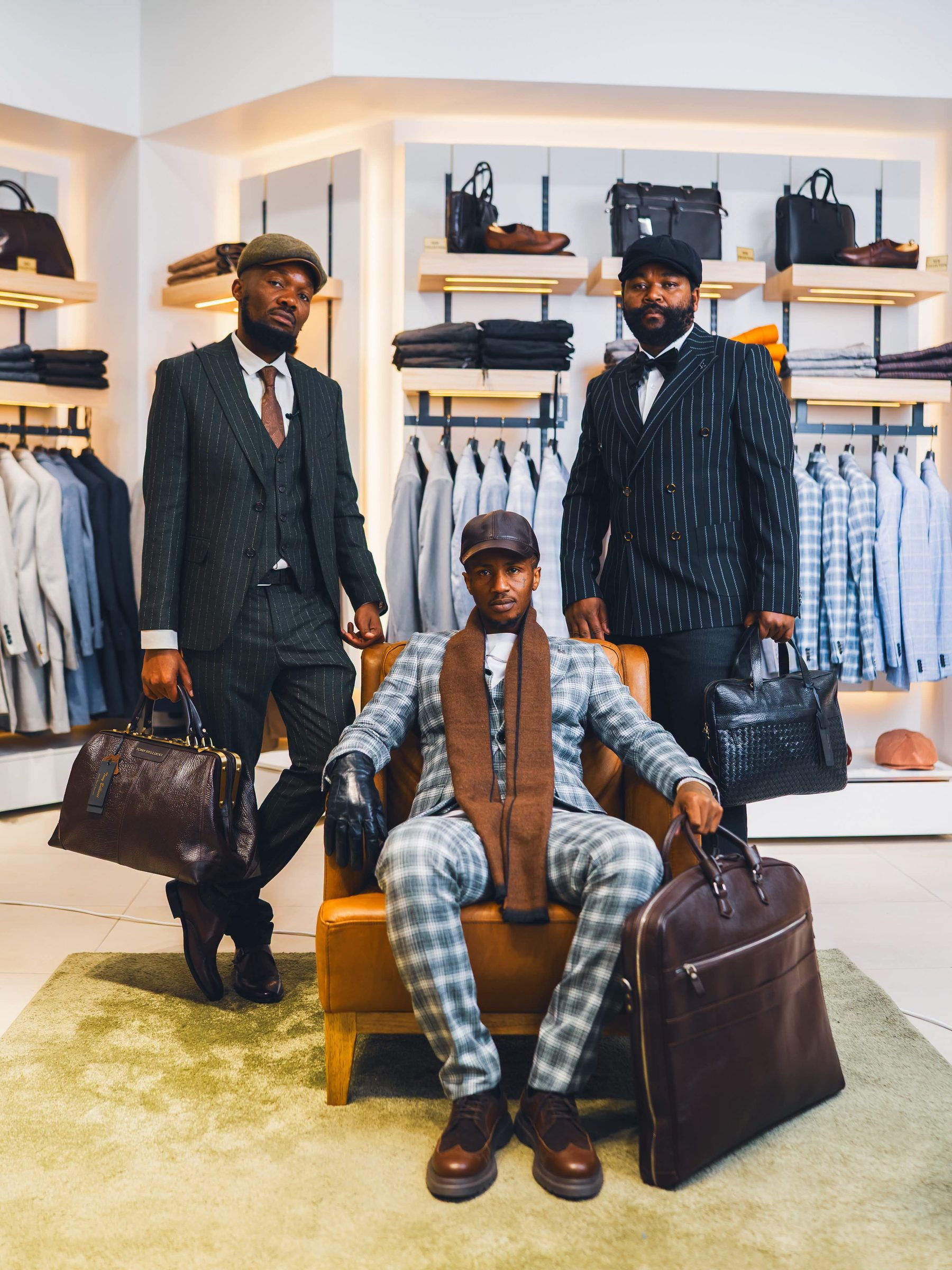 Three men in tailored pinstripe and check suits inside a COMPACT Menswear store